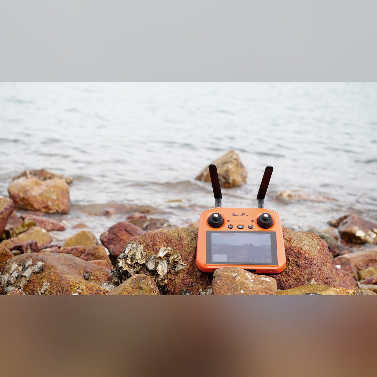 SwellPro SplashDrone 4+ R03 controller on rocks with live feed
