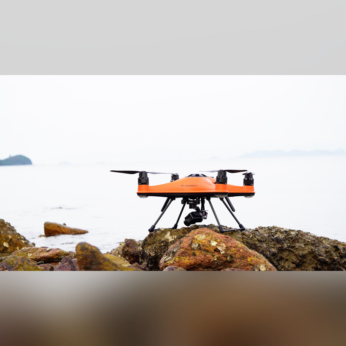 SwellPro SplashDrone 4+ hovering over rocks with water spray
